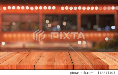 Empty wooden table top with blurred festive bokeh lights at night market Empty wooden table top with blurred festive bokeh lights at night market 142251501