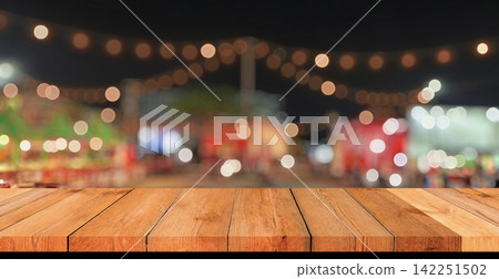 Empty wooden table top with blurred festive bokeh lights at night market Empty wooden table top with blurred festive bokeh lights at night market 142251502