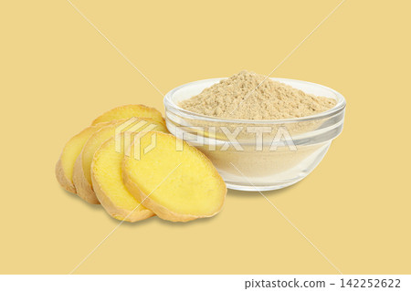 Fresh ginger slices are elegantly arranged next to a bowl of ginger powder Fresh ginger slices are elegantly arranged next to a bowl of ginger powder 142252622