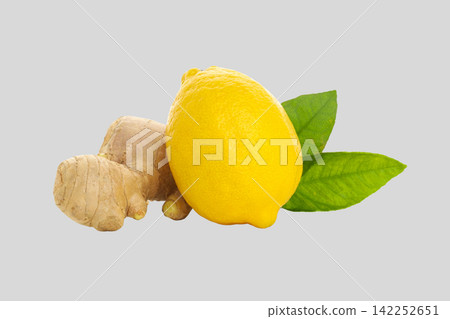 Fresh ginger root sits beside a vibrant lemon with green leaves Fresh ginger root sits beside a vibrant lemon with green leaves 142252651