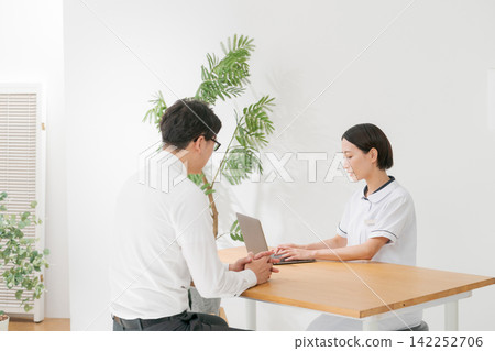 一位女診所接待員和一位男病人 一位女診所接待員和一位男病人 142252706