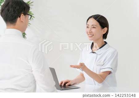 A female receptionist at a beauty salon and a male customer. A female receptionist at a beauty salon and a male customer. 142253148