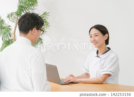 美容院的女接待員和一位男顧客。 美容院的女接待員和一位男顧客。 142253150