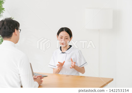 美容院的女接待員和一位男顧客。 美容院的女接待員和一位男顧客。 142253154