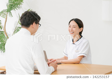 美容院的女接待員和一位男顧客。 美容院的女接待員和一位男顧客。 142253157
