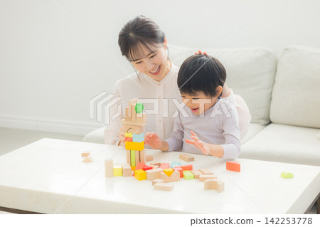Parents playing with building blocks Parents playing with building blocks 142253778