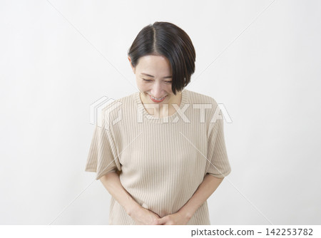 一位中年婦女面帶微笑，鞠躬致意；白色背景。 142253782