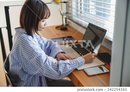 一名女性正在使用電腦，上半身像。 142254381