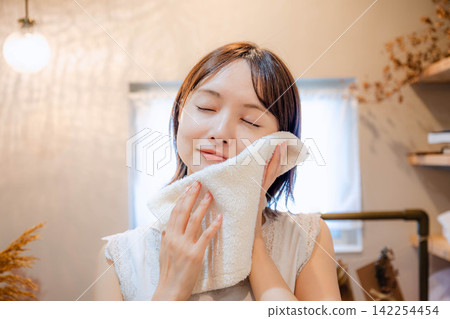 一位二十多歲的女子正在使用毛巾 一位二十多歲的女子正在使用毛巾 142254454