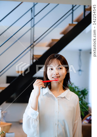 一位二十多歲的女子在室內微笑。 一位二十多歲的女子在室內微笑。 142254545
