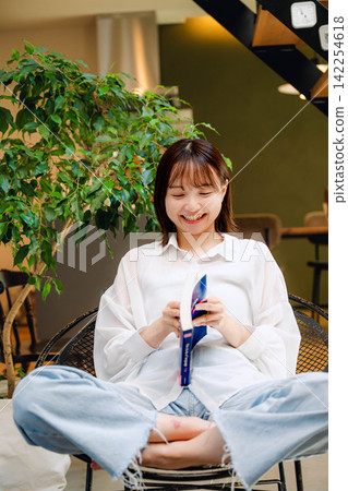 一位二十多歲的女子在室內微笑。 一位二十多歲的女子在室內微笑。 142254618