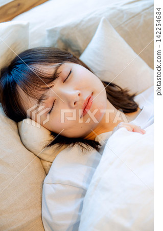一個睡在床上的年輕女人 一個睡在床上的年輕女人 142254684