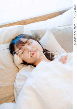 一位女子正在臥室裡睡覺 一位女子正在臥室裡睡覺 142254685
