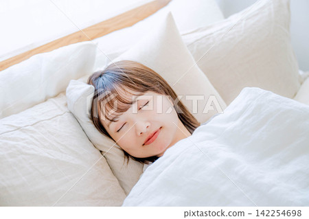 A young woman resting in bed 142254698