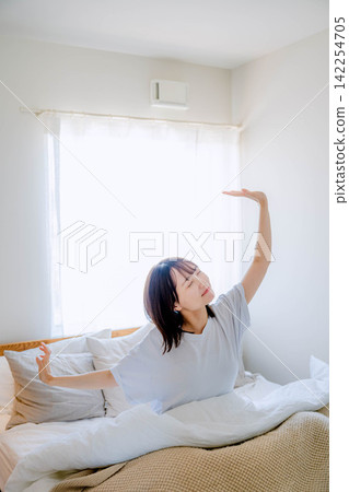 一個女人在床上醒來。 一個女人在床上醒來。 142254705