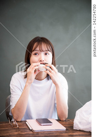 The upper body of a woman in her 20s spending time indoors 142254780