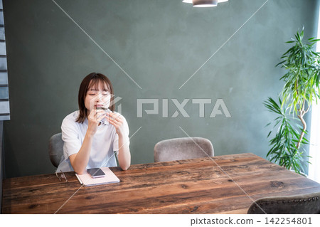 A lifestyle of a woman in her 20s spending time at a table A lifestyle of a woman in her 20s spending time at a table 142254801