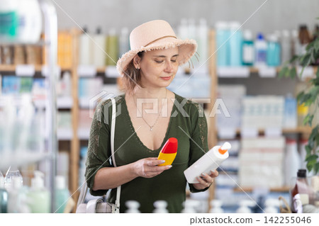 Woman buyer select sunscreen cream Woman buyer select sunscreen cream 142255046
