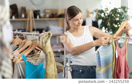 Adult woman choosing summer clothes in store 142255250