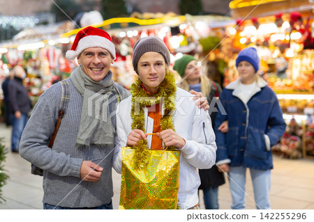 Portrait of happy father with daughter and son at christmas fair Portrait of happy father with daughter and son at christmas fair 142255296