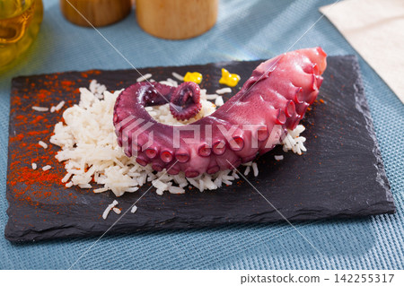 Octopus tentacles served with rice on a wooden board Octopus tentacles served with rice on a wooden board 142255317