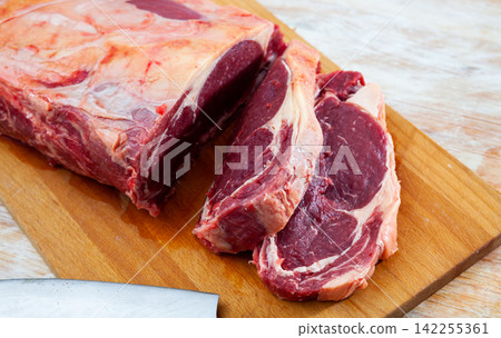 Pieces of raw boneless beef tenderloin on wooden background Pieces of raw boneless beef tenderloin on wooden background 142255361