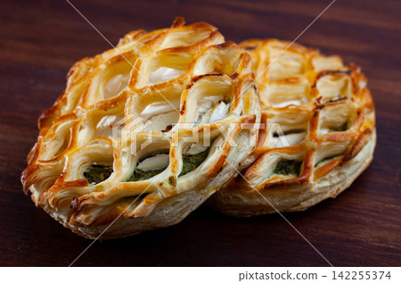 Puffs with goat cheese and spinach on wooden background Puffs with goat cheese and spinach on wooden background 142255374