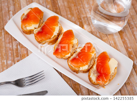 Sandwiches with smoked salmon and butter on white plate Sandwiches with smoked salmon and butter on white plate 142255385
