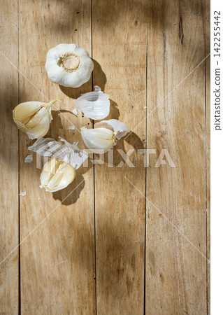 Fresh Garlic on Sunny Old Wooden Kitchen Table, Top View Fresh Garlic on Sunny Old Wooden Kitchen Table, Top View 142255442