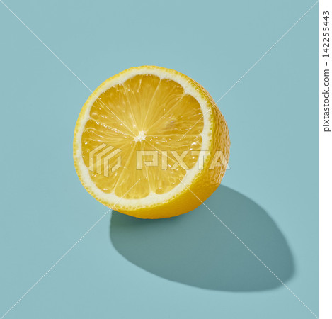 Fresh Half Lemon on Sunny Blue Background Fresh Half Lemon on Sunny Blue Background 142255443