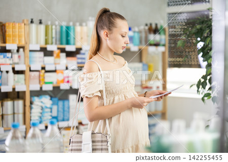 Pregnant woman with prescription in drugstore 142255455