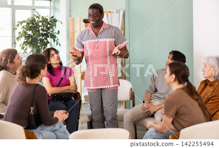 Middle-aged man standing and speaking during circle discussion 142255494