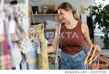 Adult woman choosing summer clothes in store 142255506