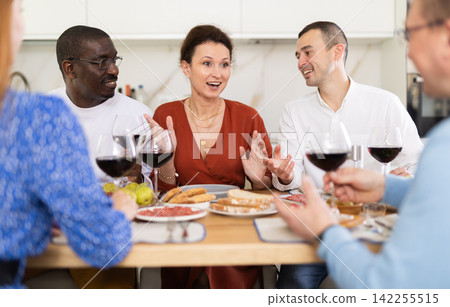 Multiethnic women and men friends chatting and drinking Multiethnic women and men friends chatting and drinking 142255515