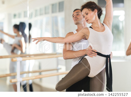 Young man and adult woman rehearsing pair ballet Young man and adult woman rehearsing pair ballet 142255527