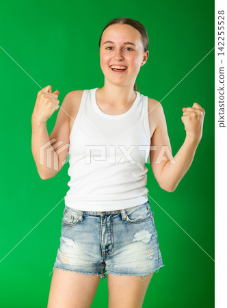 Happy teenage girl in front of green screen Happy teenage girl in front of green screen 142255528