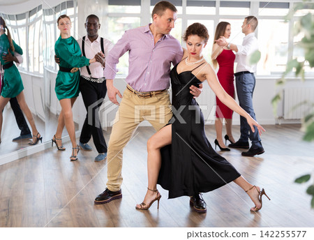 Middle-aged man and woman practicing waltz in dancing studio Middle-aged man and woman practicing waltz in dancing studio 142255577