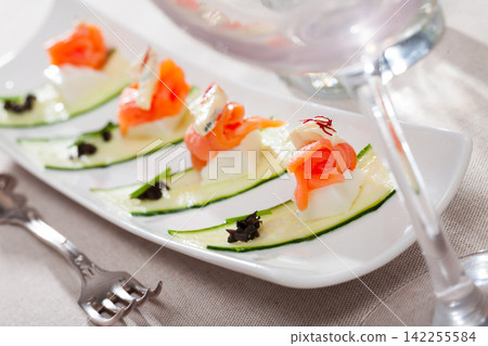 Tasty salmon with two types of cheese and fresh cucumber at plate Tasty salmon with two types of cheese and fresh cucumber at plate 142255584