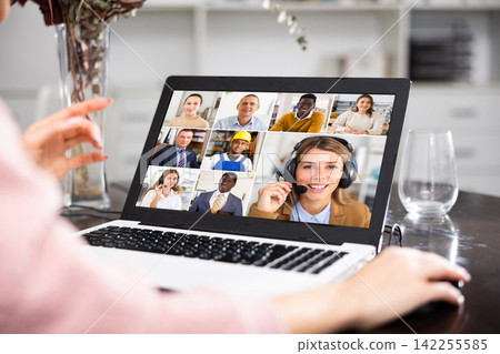 Young woman is holding a video conference on a laptop Young woman is holding a video conference on a laptop 142255585