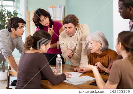 Men and women of different ages actively communicating at table Men and women of different ages actively communicating at table 142255599