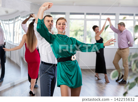 Woman and young man practicing waltz in dancing studio Woman and young man practicing waltz in dancing studio 142255632