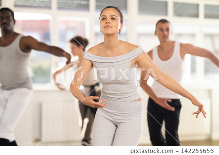Concentrated women and men rehearsing ballet dance in class Concentrated women and men rehearsing ballet dance in class 142255656