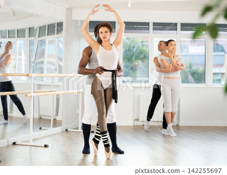 Confident ballet dancer supporting female partner in lifts Confident ballet dancer supporting female partner in lifts 142255697