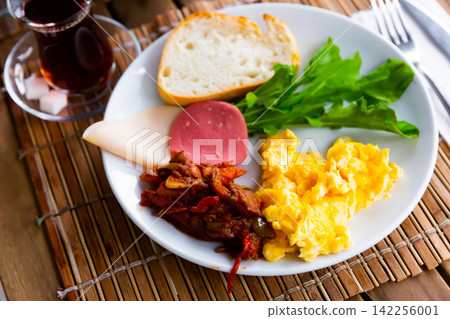 Turkish breakfast: egg, vegetables, cheeses, olives and ham. Turkish breakfast: egg, vegetables, cheeses, olives and ham. 142256001