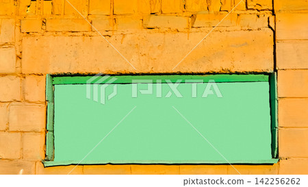 Bright green plywood board frame on orange brick wall Bright green plywood board frame on orange brick wall 142256262