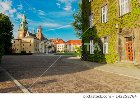 Historic European castle complex in Krakow Poland with cobblestone courtyard and ivy-covered walls 142258764