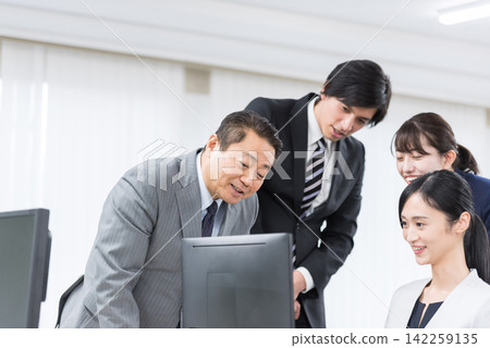 A business team working in an office. Work, workplace, teamwork, management, human resources, company, support, unity A business team working in an office. Work, workplace, teamwork, management, human resources, company, support, unity 142259135