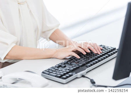 Woman using a computer at the office Woman using a computer at the office 142259254