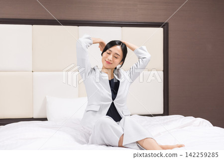Business woman working to relax in a hotel bed Business woman working to relax in a hotel bed 142259285