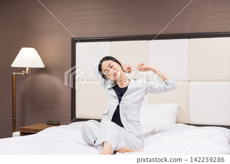 工作在旅館床上放鬆的女商人 142259286